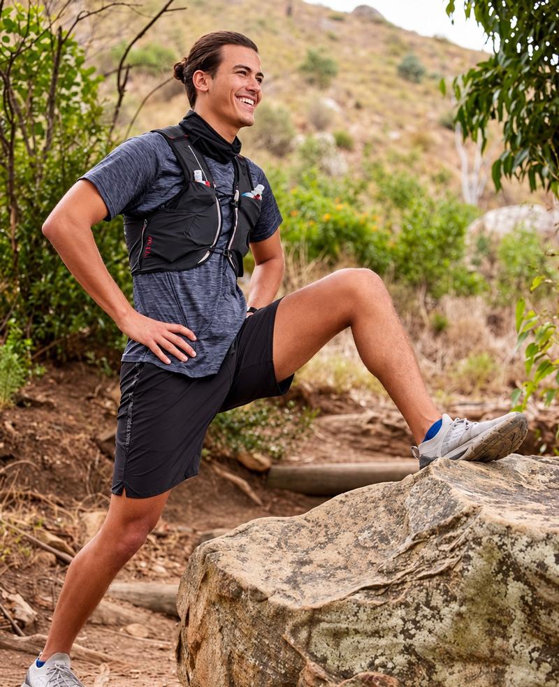 Smiling man resting on a rock during a hike